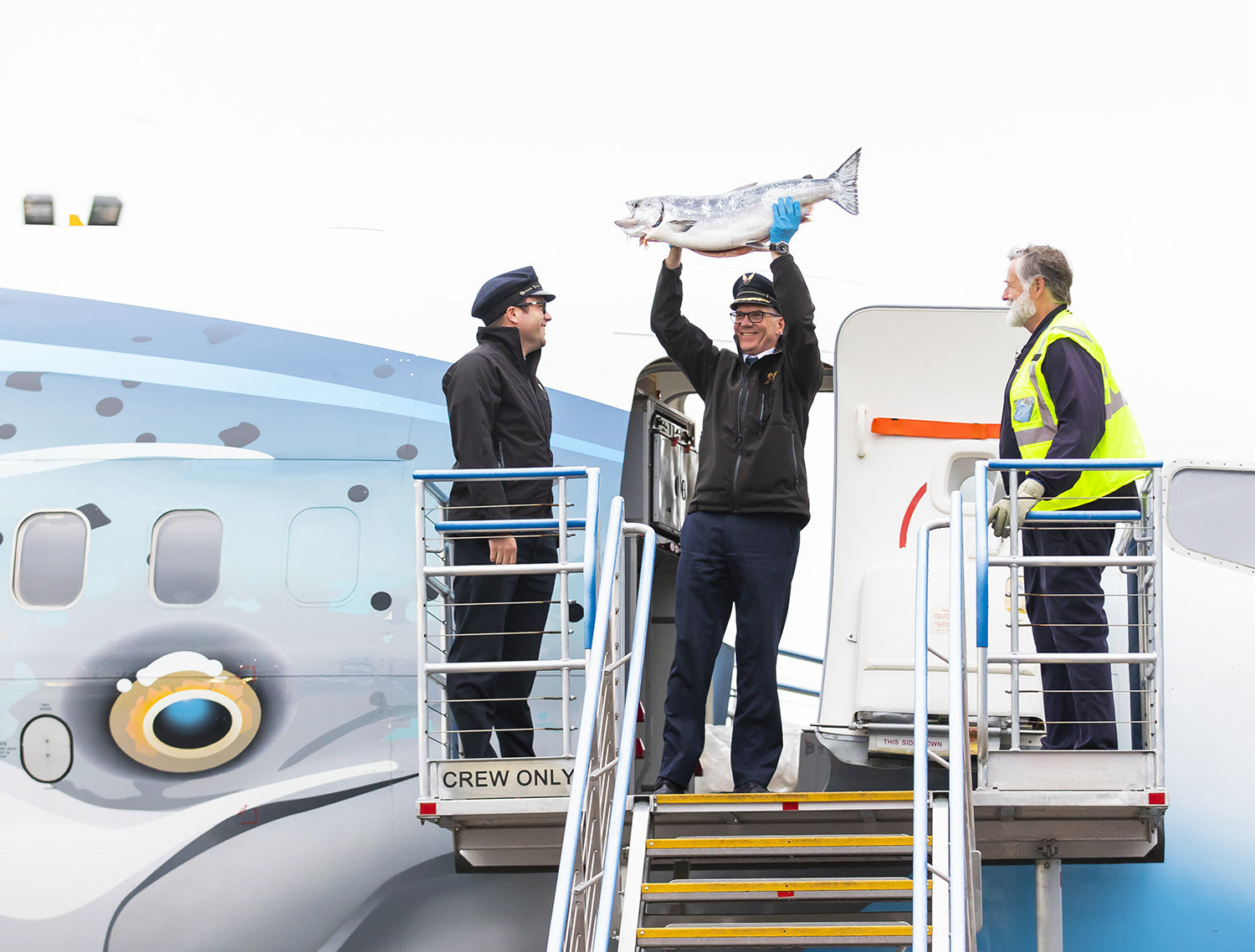 Alaska Airlines pilots hold up the first Copper River Salmon upon arrival in Seattle