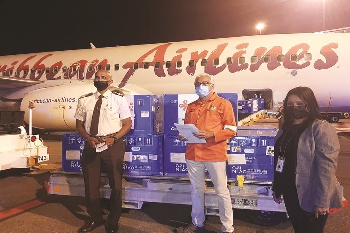 Trinidad and Tobago Minister of Health, The Honourable Terrence Deyalsingh (middle) takes possession of the Sinopharm vaccines alongside Caribbean Airlines