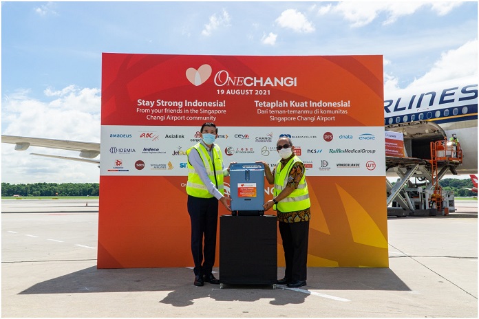 Mr Lee Seow Hiang (left) hands over an oxygen concentrator to Mr. Suryo Pratomo at Changi Airport, on Aug 19, 2021. PHOTO: CHANGI AIRPORT GROUP