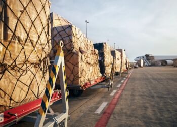 Loading of cargo containers to airplane at airport.
